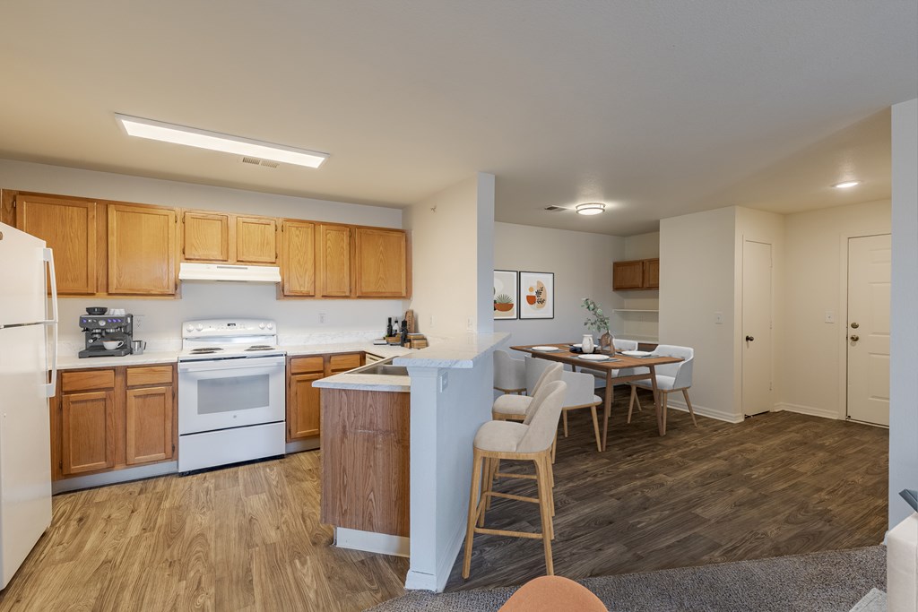A kitchen with wooden cabinets and a white fridge.