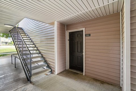 A staircase with a metal railing leads to a door with a number 405 on it.