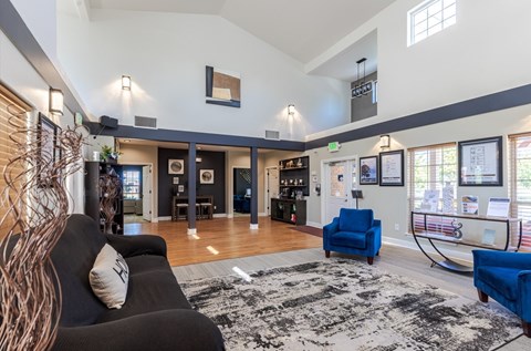 A living room with a black couch and a blue chair.