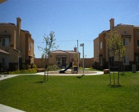 a playground in a yard in front of some apartments
