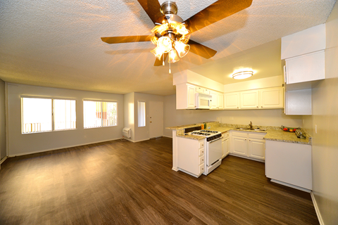 a kitchen with white cabinets and a ceiling fan