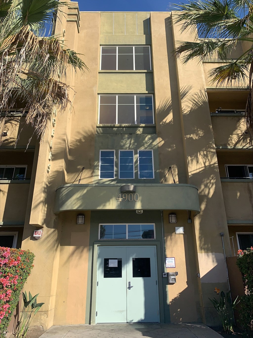 A building with a blue door and windows with shutters.