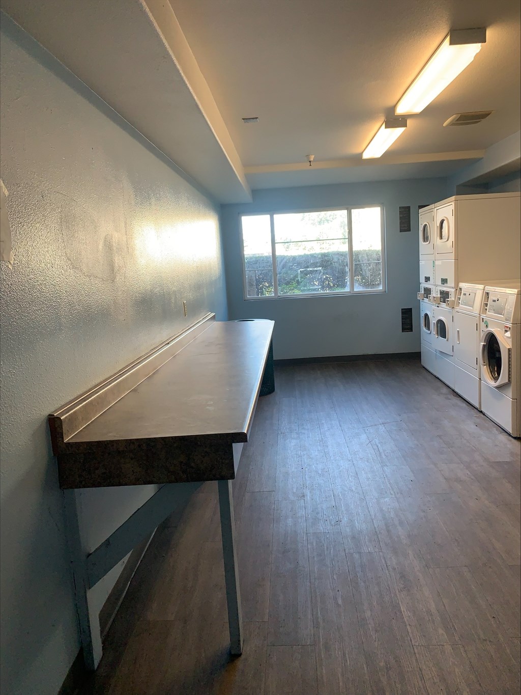 A laundry room with a washer and dryer and a table.