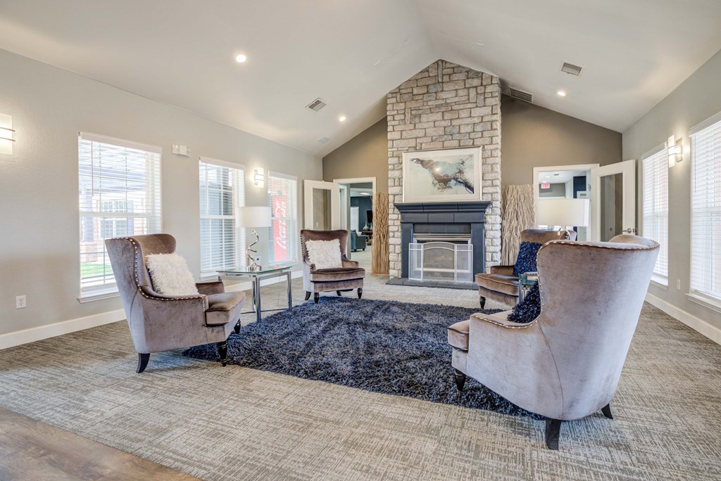 A living room with a stone fireplace and a large chair.
