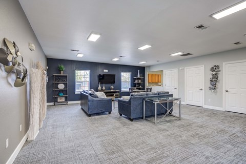 A spacious room with a blue couch and a desk.