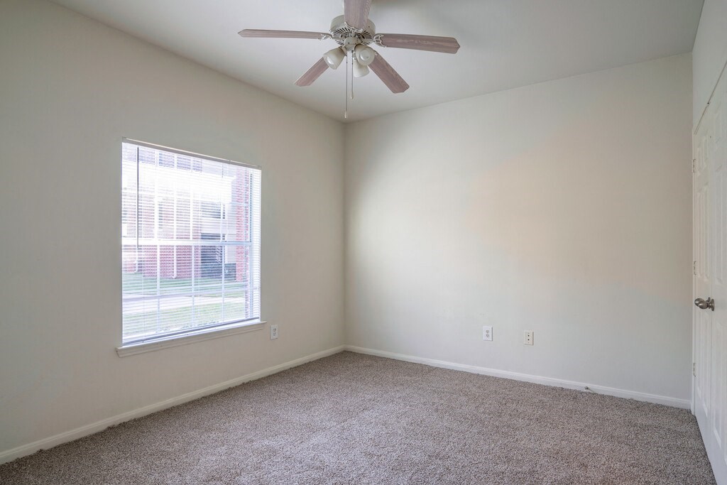 a bedroom with a ceiling fan and a window