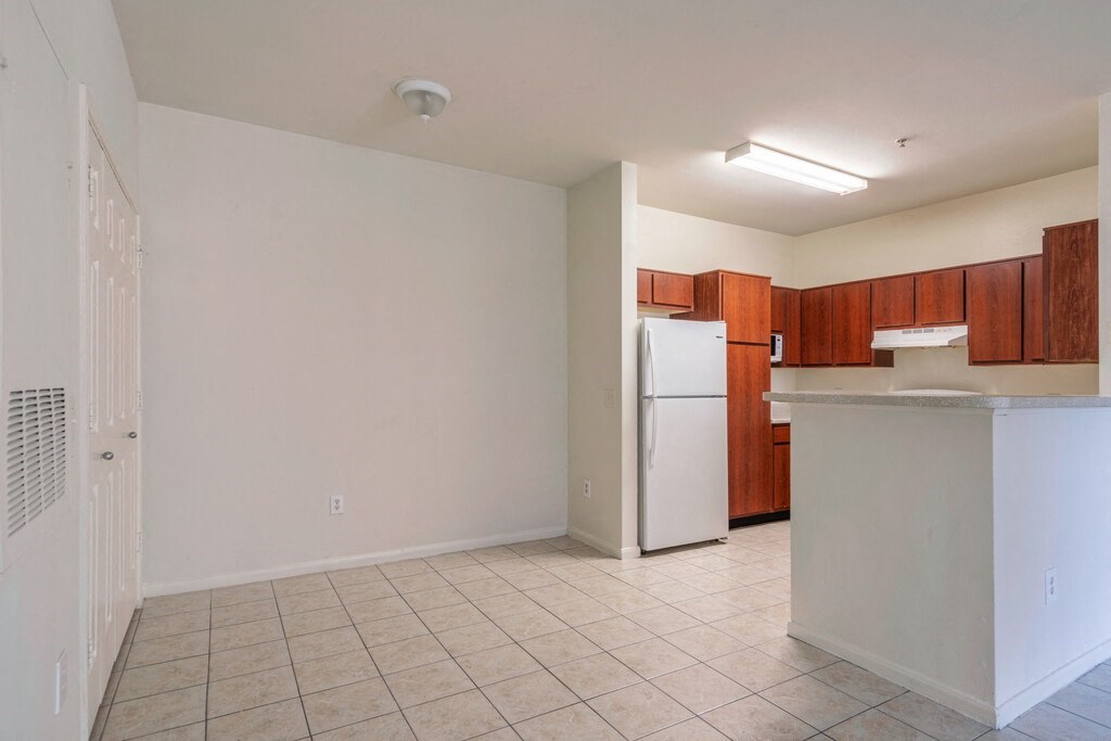 a kitchen with a white refrigerator freezer next to a stove top oven