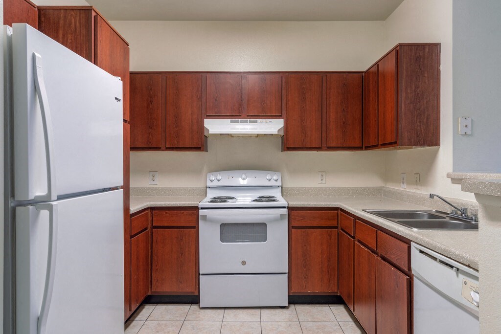 a kitchen with white appliances and wooden cabinets