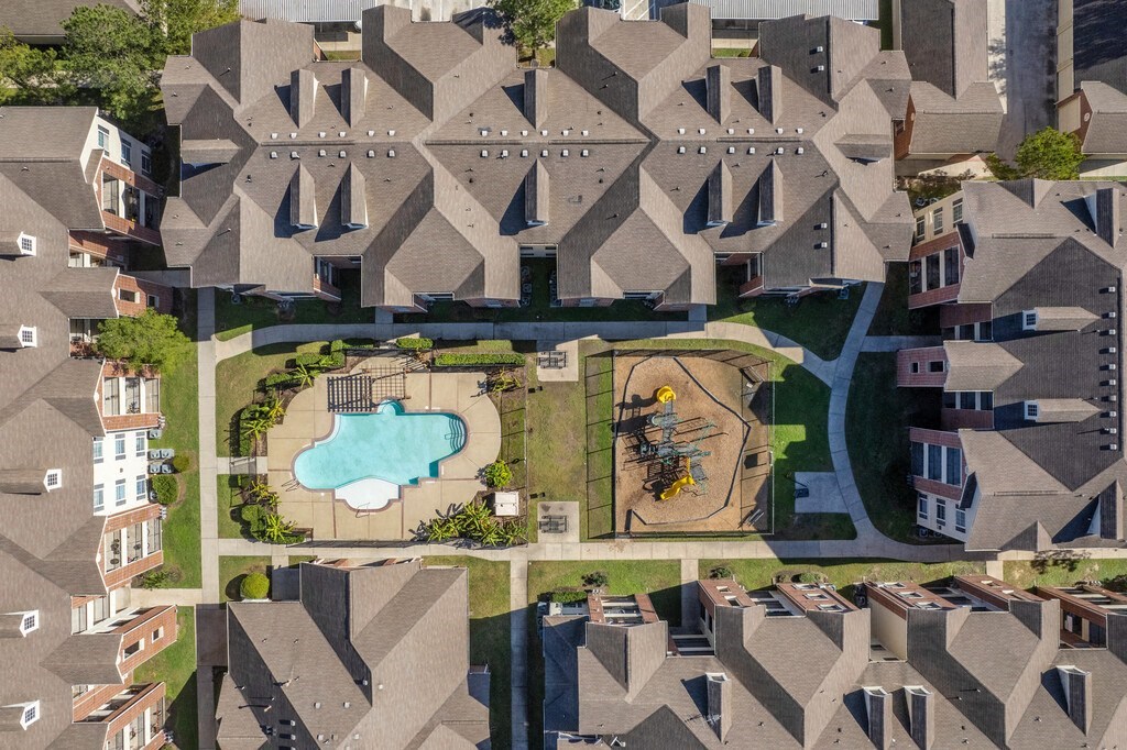 a birdseye view of a suburban neighborhood with a large pool in the middle of the apartment complex