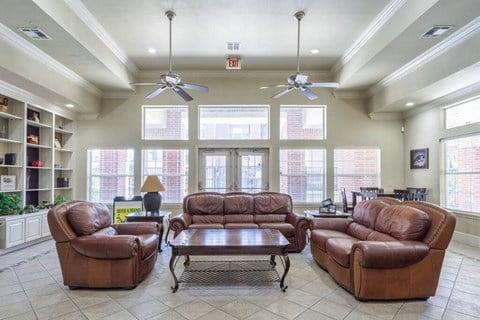 a large living room with leather couches and a table