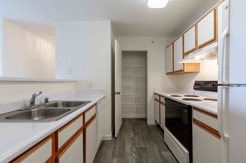 A kitchen with white cabinets and a white refrigerator.