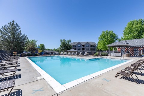 A large outdoor swimming pool surrounded by lounge chairs.