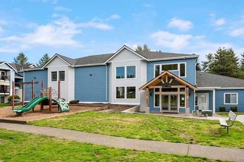 a blue house with a yard with a playground