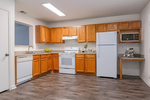 A kitchen with wooden cabinets and white appliances.