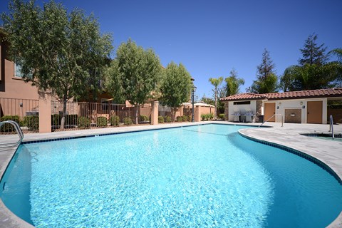 a swimming pool at a resort style hotel with trees and a building