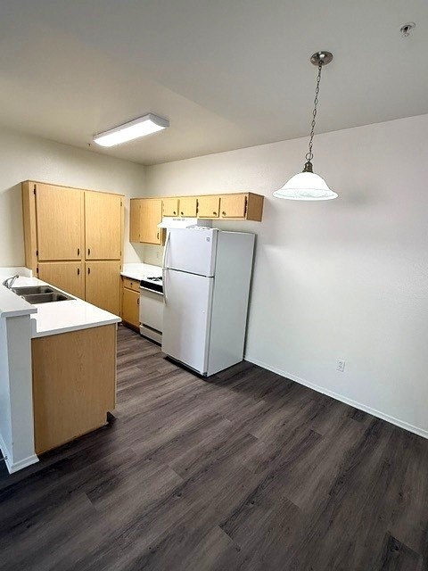 A kitchen with wooden cabinets and a white refrigerator.