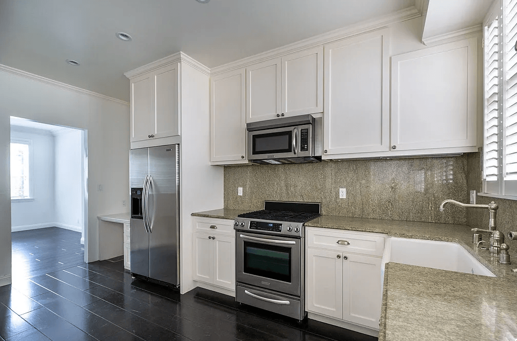 a kitchen with white cabinets and stainless steel appliances