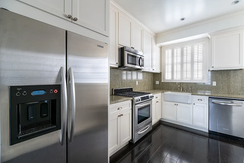 a kitchen with stainless steel appliances and white cabinets