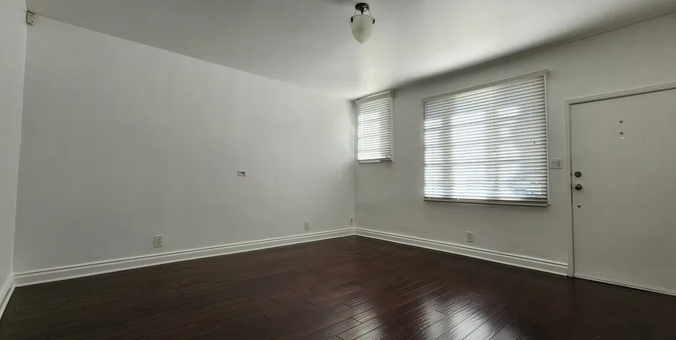 an empty room with a window and a door