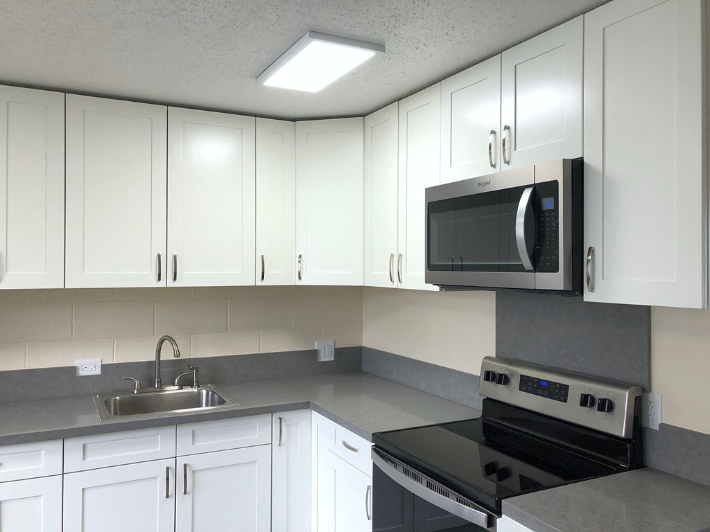 Hale Makiki Apartments kitchen area with appliances and cabinets