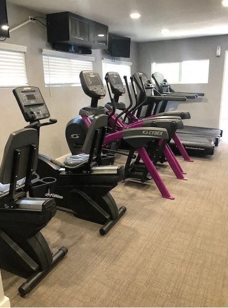 a group of exercise machines in a gym room
