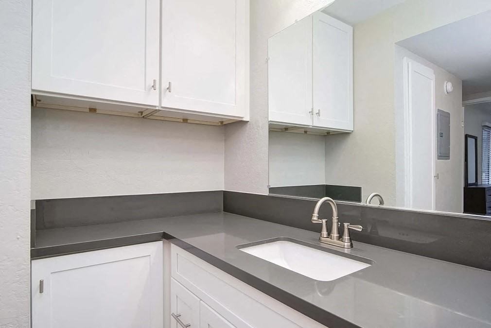 a white kitchen with white cabinets and a sink