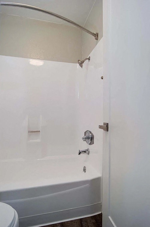 a white bathroom with a tub and a toilet