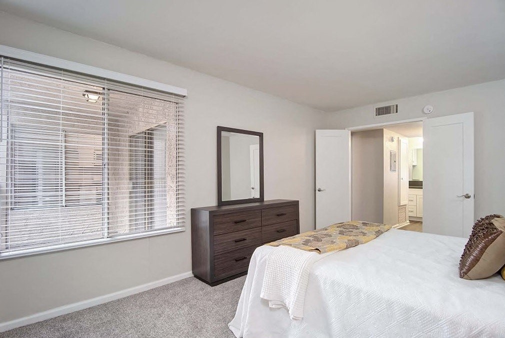 a bedroom with a bed and a large window
