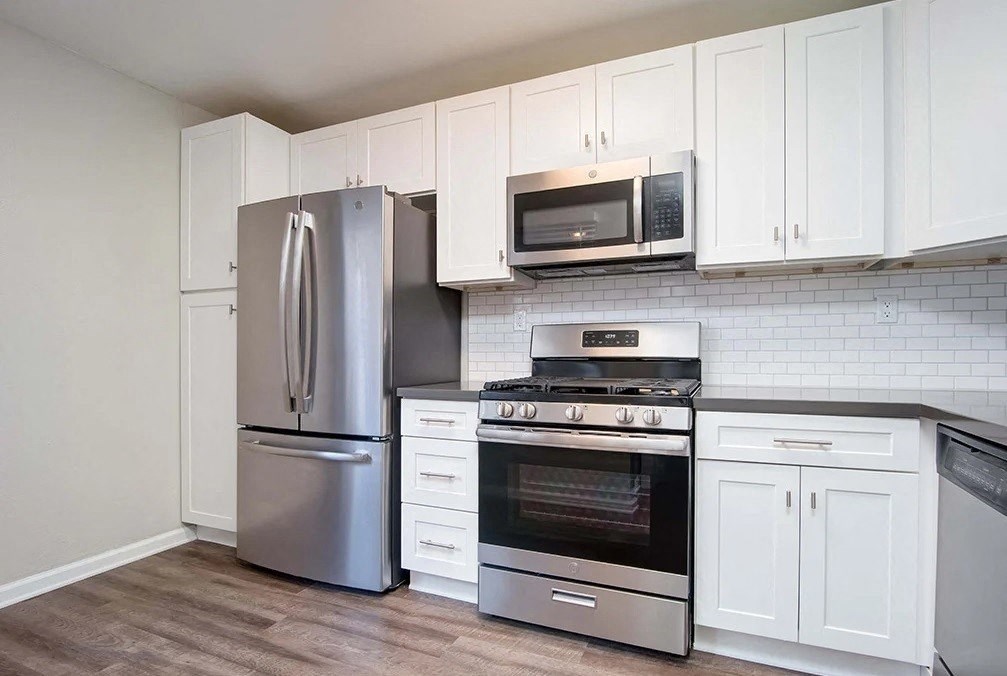 a kitchen with stainless steel appliances and white cabinets