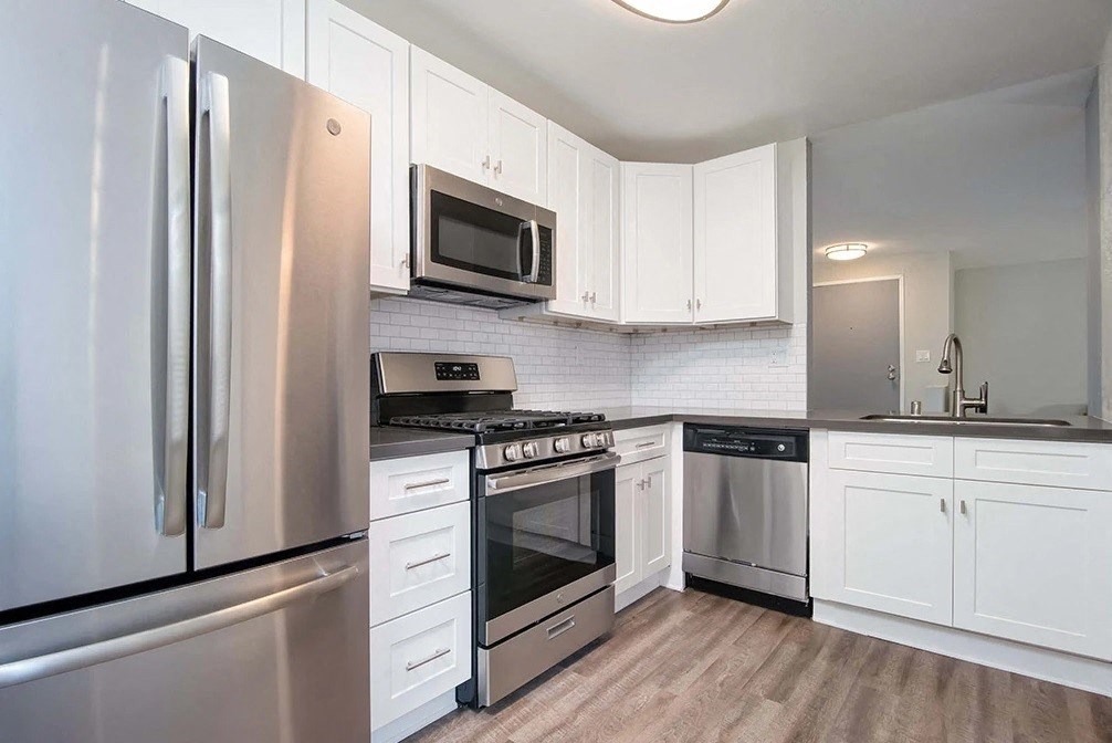 a kitchen with stainless steel appliances and white cabinets
