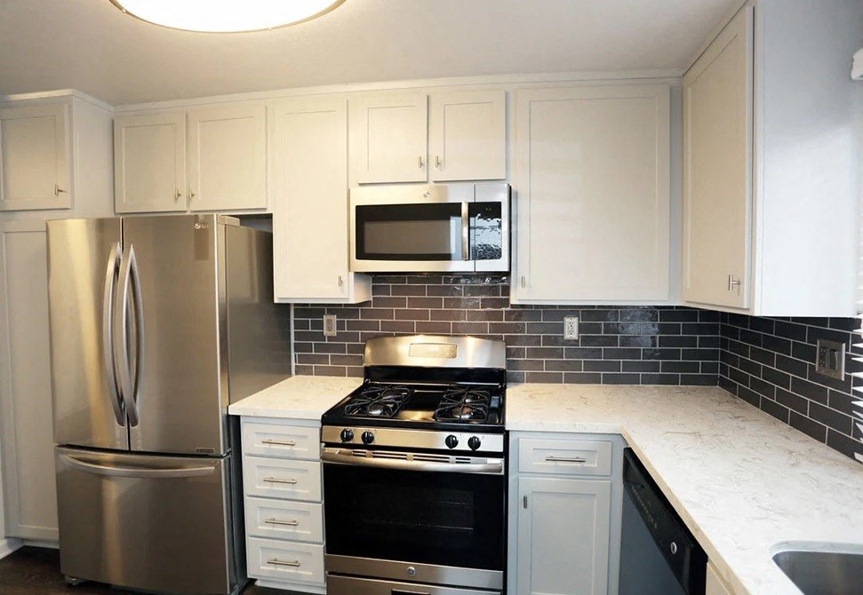 a kitchen with stainless steel appliances and white cabinets