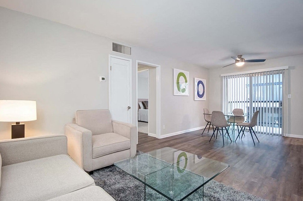 a living room and dining room with a glass table