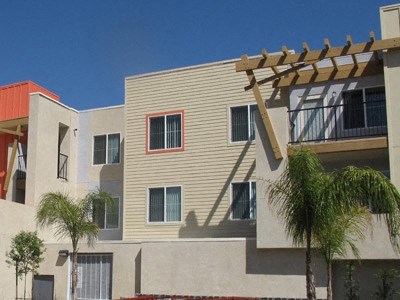 an apartment building with awning and palm trees in front of it