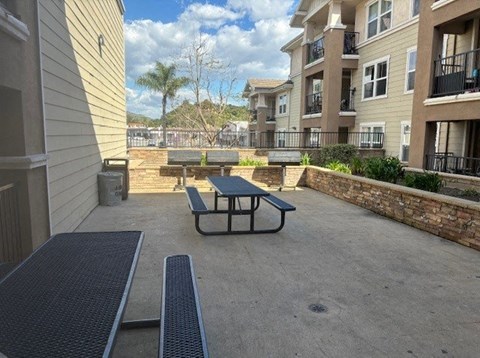 A patio with a table and chairs is surrounded by apartment buildings.