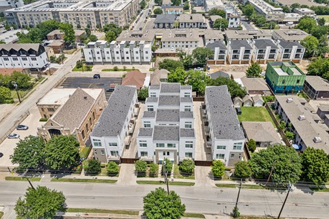 A bird's eye view of a residential area with apartment buildings and trees.