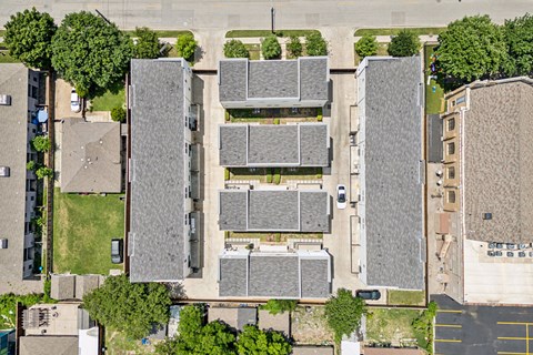 A parking lot is surrounded by apartment buildings.
