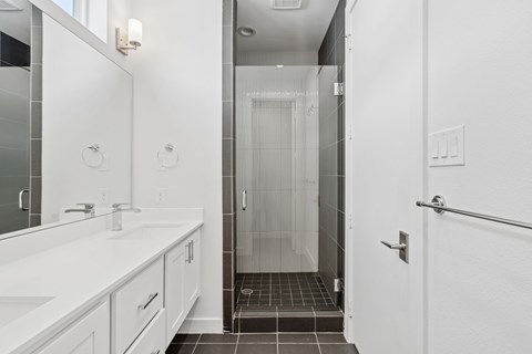 A white bathroom with a walk in shower.