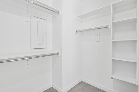 A white closet with shelves and a door.