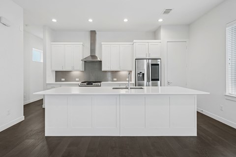 A modern kitchen with white cabinets and a large island.