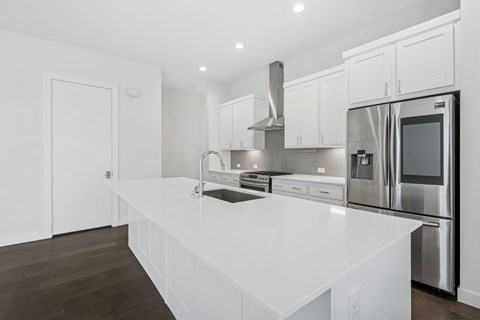 A modern kitchen with white cabinets and stainless steel appliances.