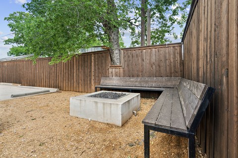 A wooden bench sits in front of a wooden fence.