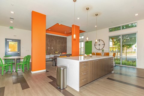 a kitchen with an island and a table with green chairs