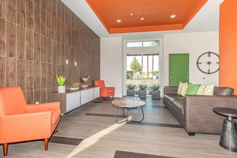 a living room with orange chairs and a couch
