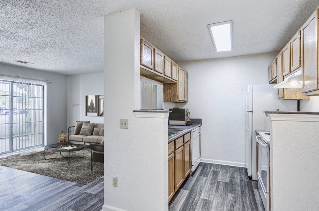 A kitchen with a refrigerator, cabinets, and a dining table.