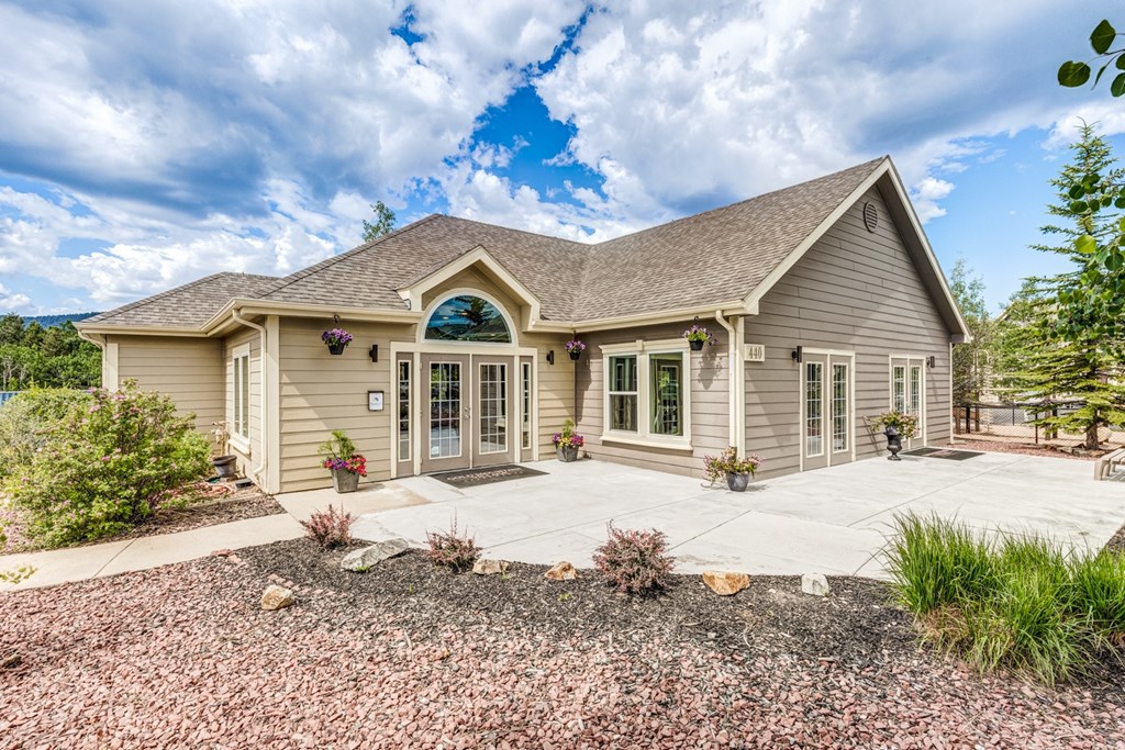 A house with a grey roof and a brown front yard.