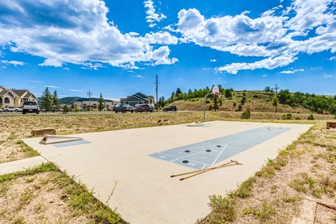 A basketball court is being constructed in a grassy area.