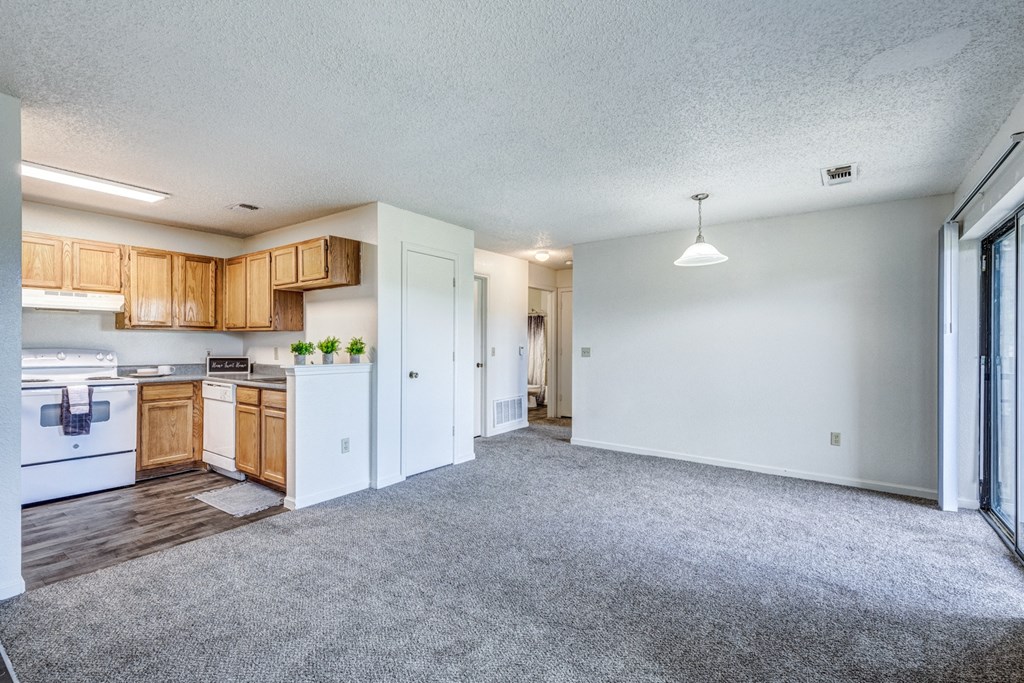 A spacious kitchen with wooden cabinets and a white refrigerator.