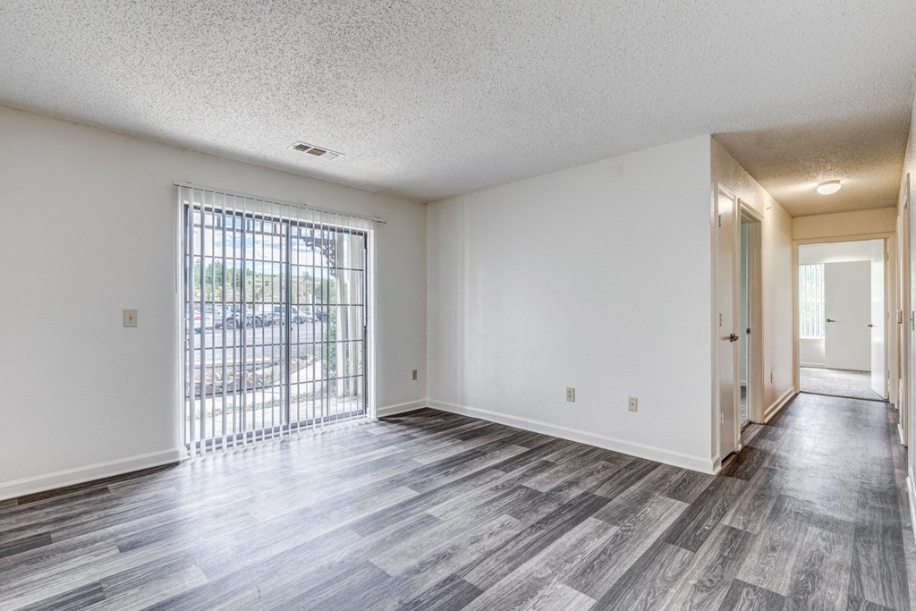 A room with a sliding glass door leading to a balcony.