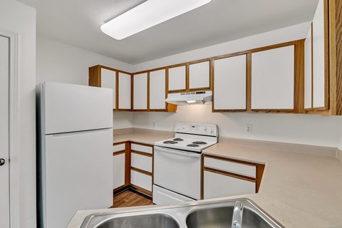 a kitchen with white appliances and wooden cabinets and a white refrigerator