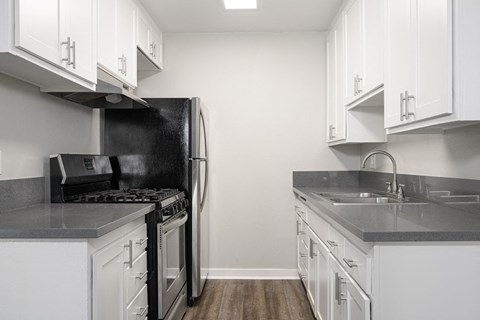 a kitchen with white cabinets and a stove and refrigerator